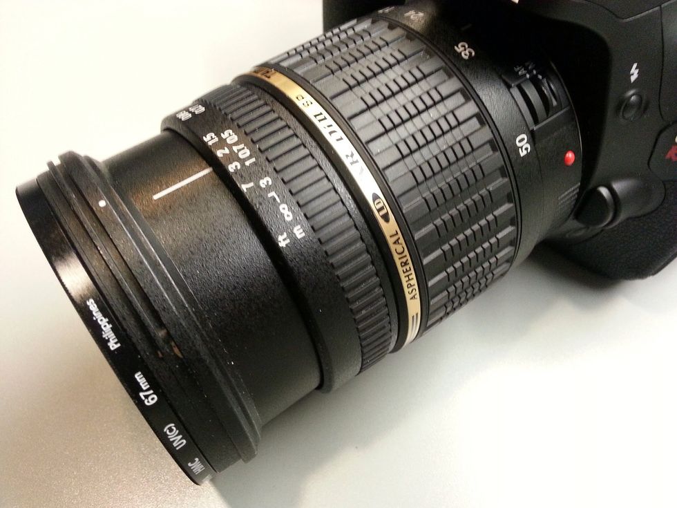 To zoom, turn the large barrel with the gold line. The small barrel in the front can be used for focus, but only if the camera is set to Manual Focus.