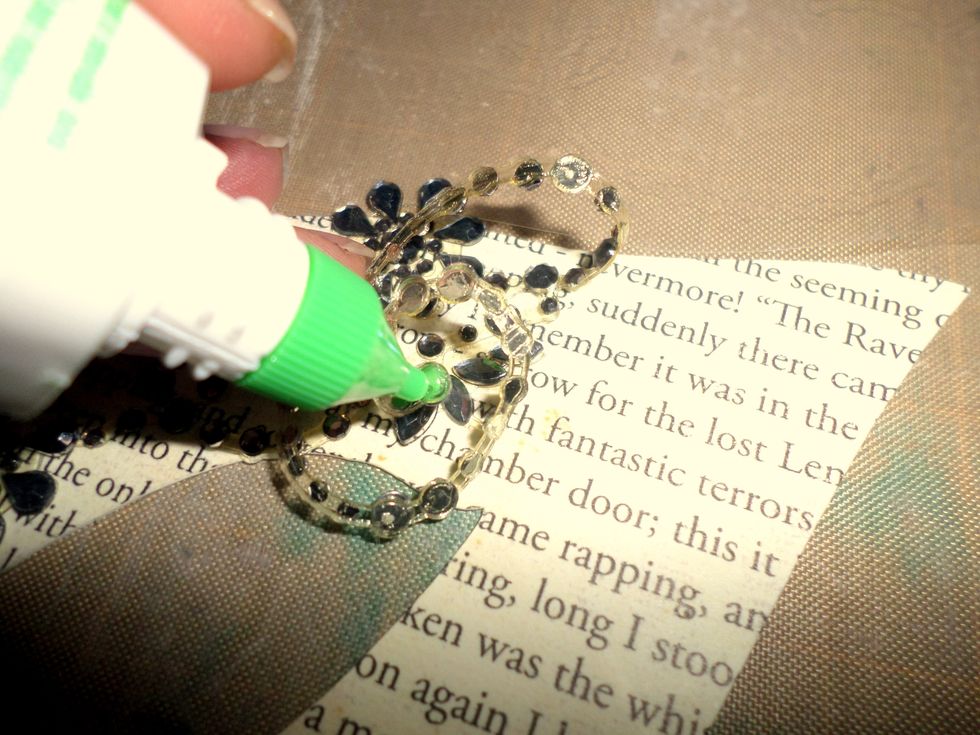 Tombow Mono Multi Adhesive is perfect for this! It has a fine tip for detail work, it goes on white and dries clear. It also has a broad tip. I used it to adhere the rhinestones to my mask.