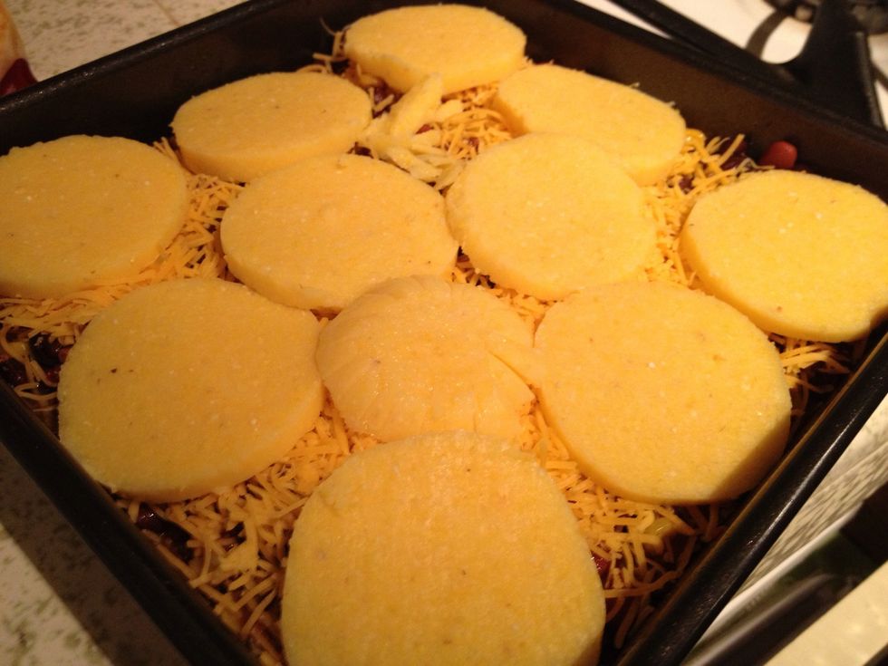 Top chili mixture with half of the cheese. Then top with the remaining polenta slices.