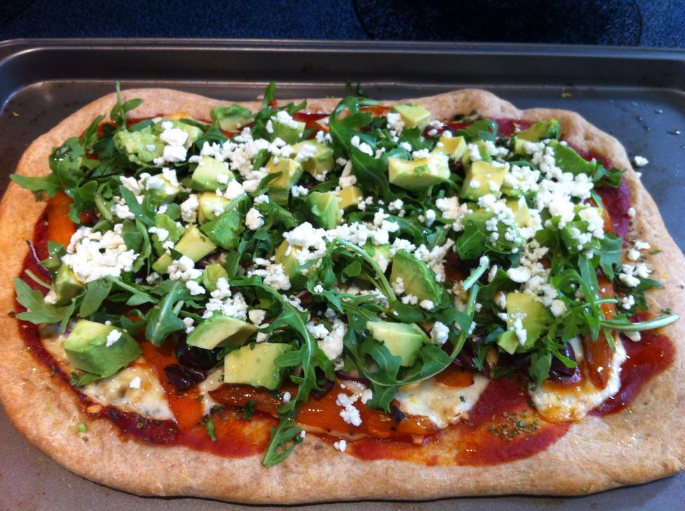 Top pizza with olives, avocado, arugula, parsley, feta cheese and lemon zest. Drizzle with olive oil.