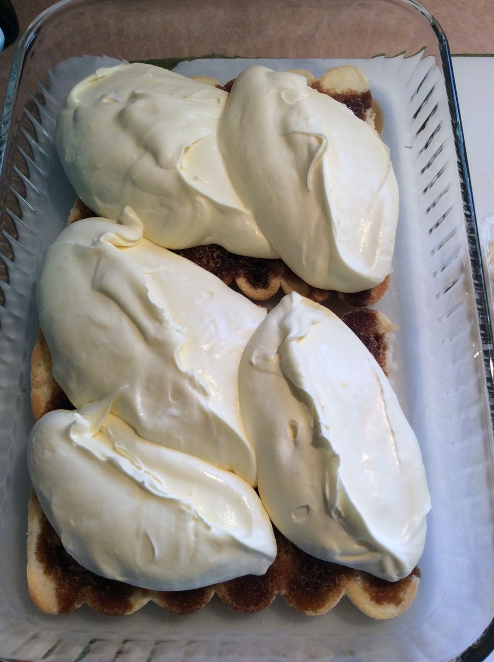 Top the drenched lady fingers with 2/3 of the whipped cream and mascarpone egg mixture.