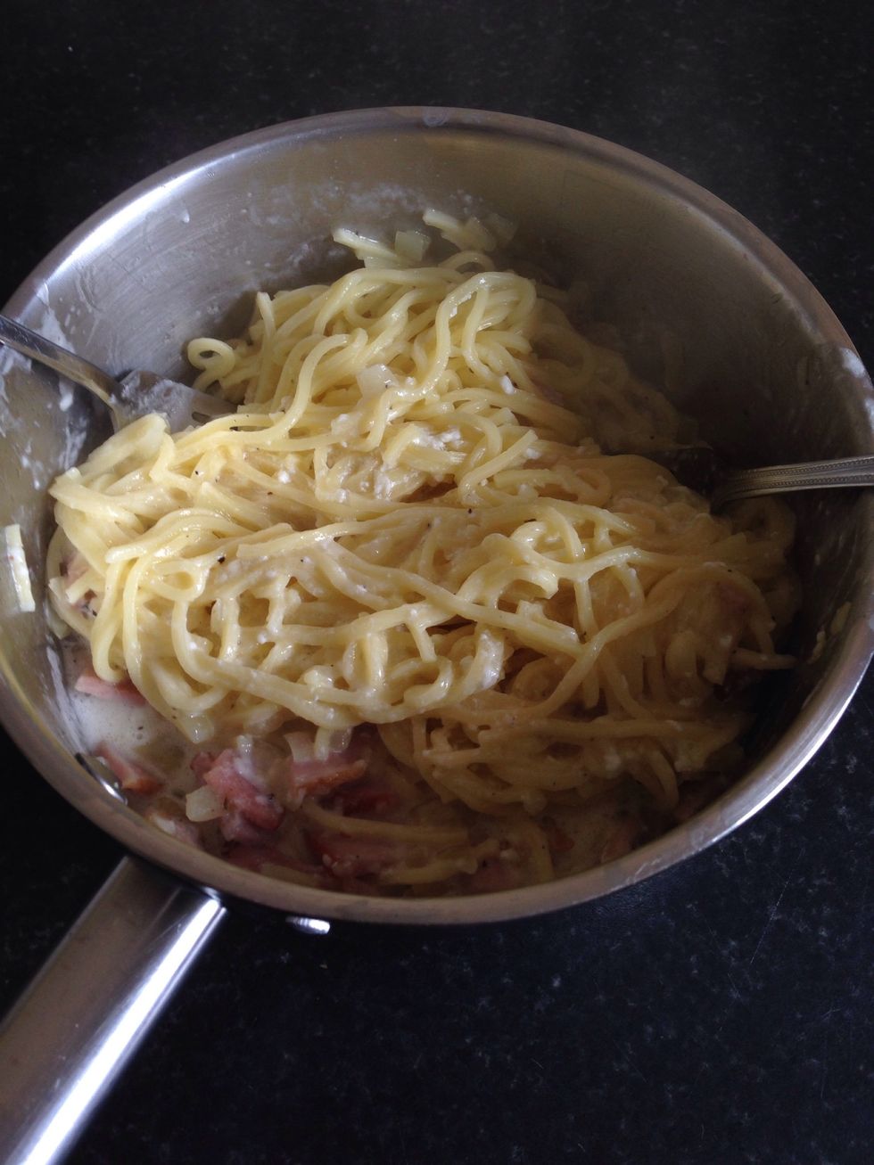 Top the pasta in the pot with sauce and rashers with onion. Mix everything together.