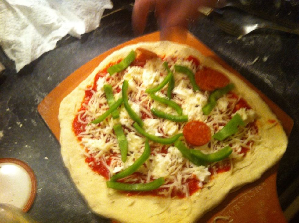 Top with your favorite toppings. For this pizza we used fresh mozzarella, pepperoni, sausage, green peppers, red onions and a small amount of shredded mozz on top.