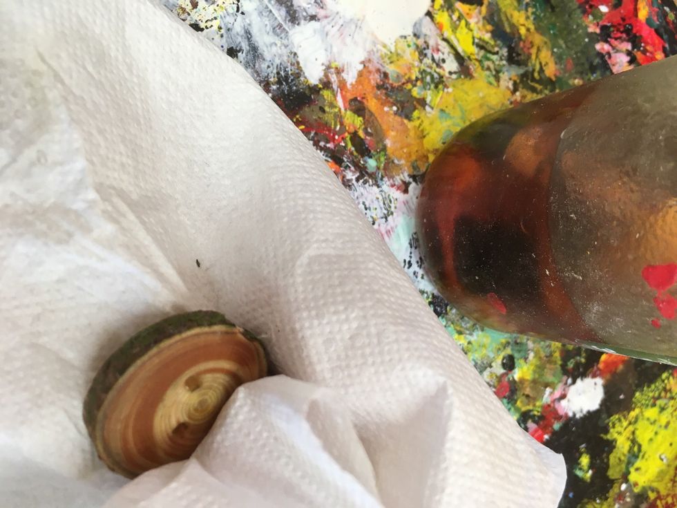 Torka av oljan som inte sugits in i knappen med papper.