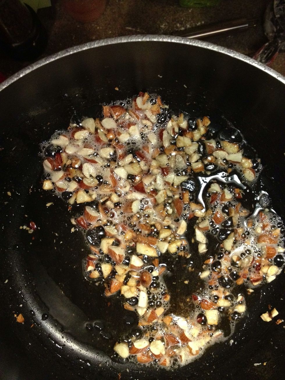 Toss almonds & garlic into the pot and saut\u00e9 until the almonds are a toasty brown color. Stir frequently and keep an eye on it - garlic is incredibly easy to burn, and you'd have to start over.