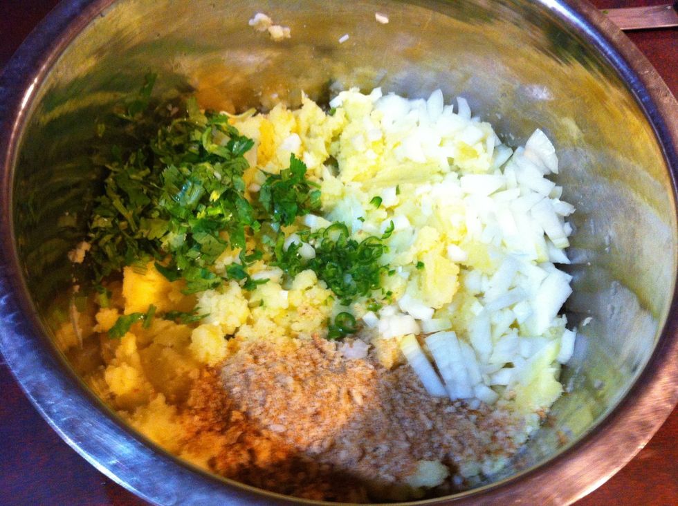 Toss in diced onions, chopped green chilies, chopped cilantro, and breadcrumbs.