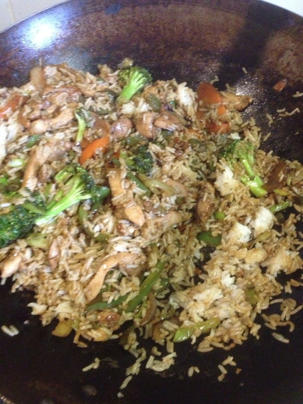 Toss in the chicken, garlic and ginger. Keep tossing, watching to ensure the chicken cooks through. Then add the sauce, two cups of rice and cook until the sauce thickens.