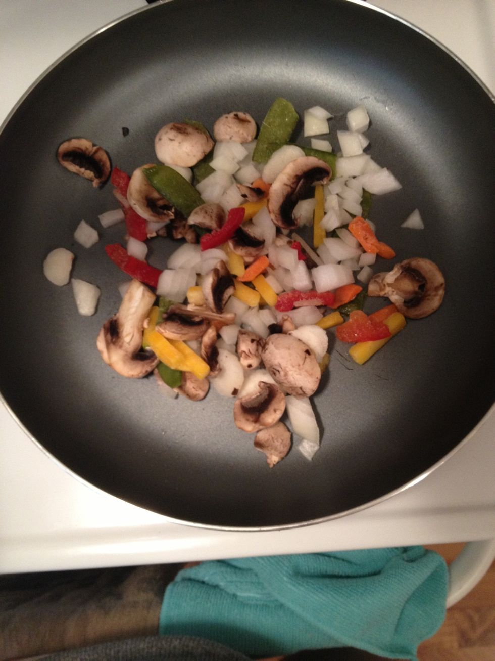 Toss the onion, and frozen veggies into a fry pan. This time I had some left over mushrooms so I tossed them in too!