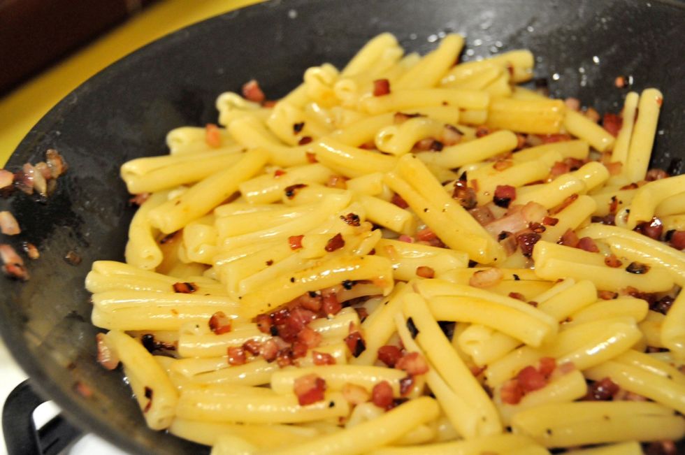 Toss the pancetta mixture with the pasta - let it saut\u00e9 for about 30-40 seconds, then remove from the heat. The heat from the noodles should be just perfect for cooking the eggs in the sauce.