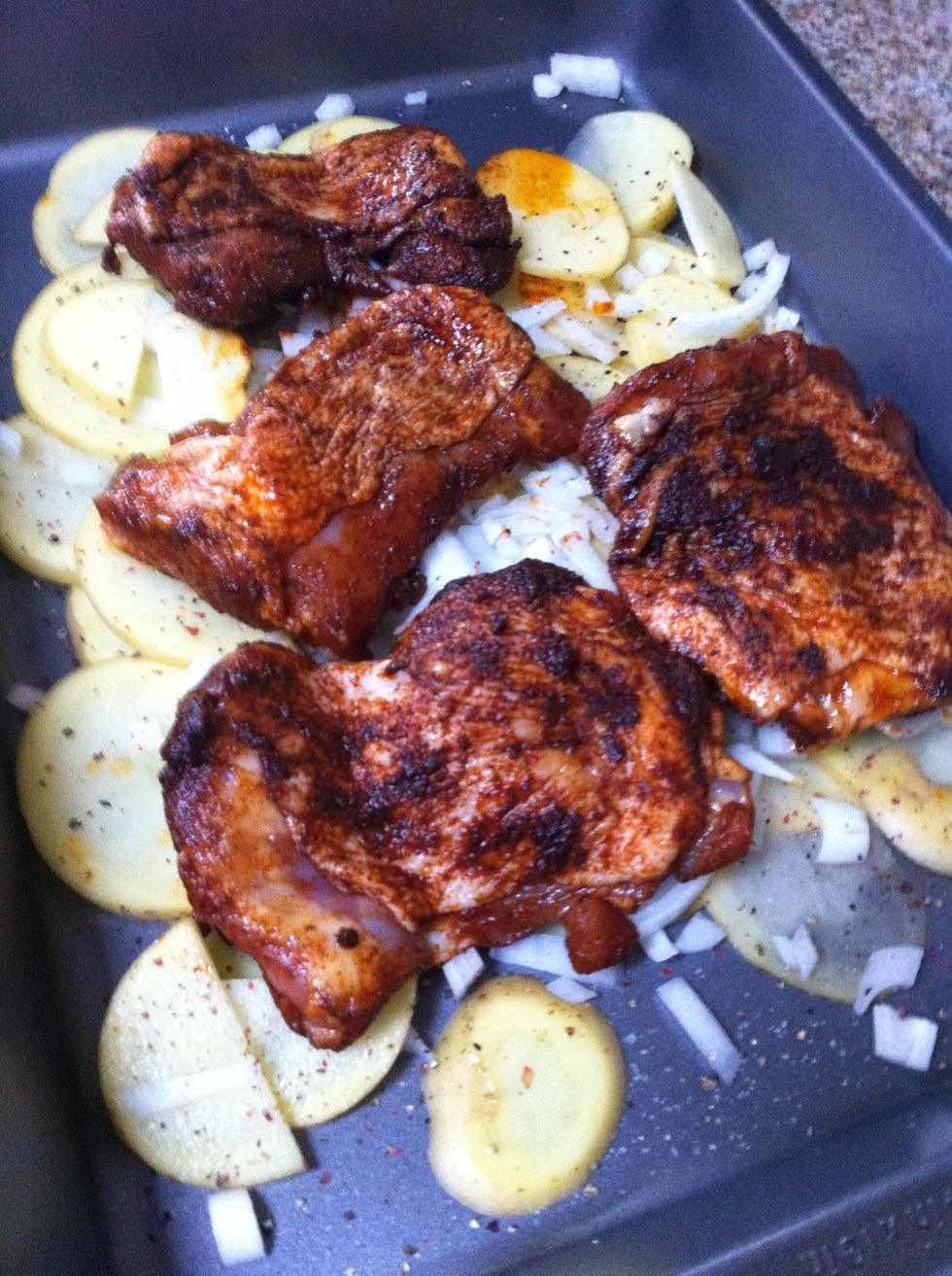 Toss the thighs, skin side up, onto the potatoes and onions. As it cooks, the juices and paprika will flavor them. Mmmmm!
