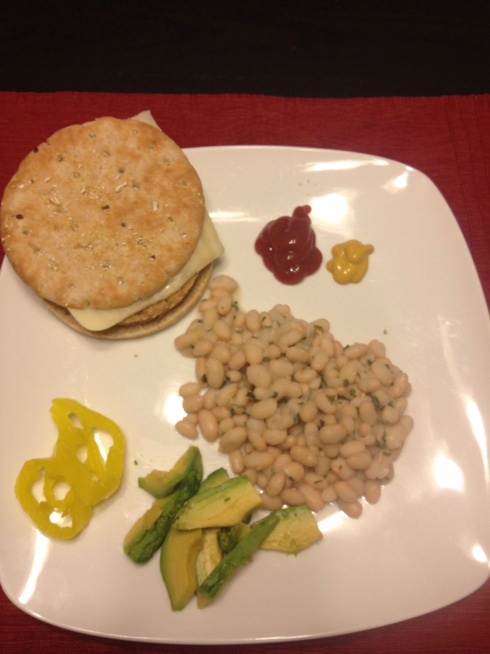 Total cals: 1/2 cup navy beans 80 1/4 avocado 62 Bread round 100 Veggie burger 70 Mozzarella cheese slice 70 1/8 cup mild pepper rings 5 Mustard 0 1/2 T ketchup 10 Total= 397 calories