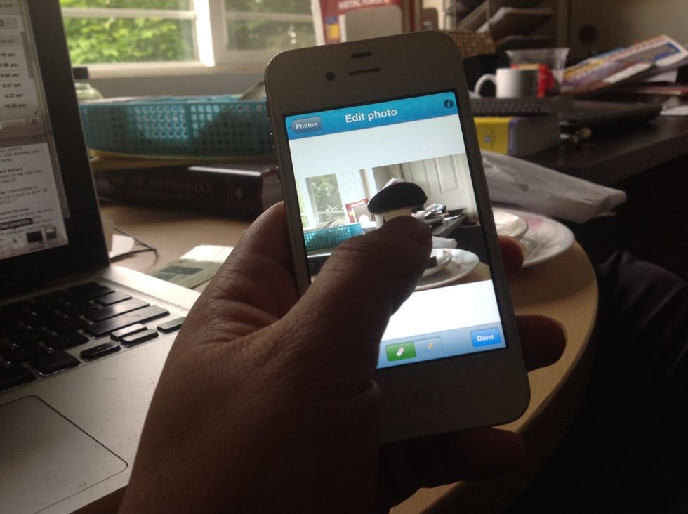 Touch and hold, you will be able to erase part of the first photo and show the background photo.