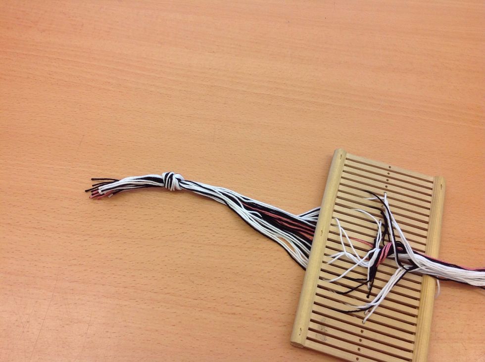 Tr\u00e4 i alla tr\u00e5dar och samla ihop till en knut bakom bandgrinden.