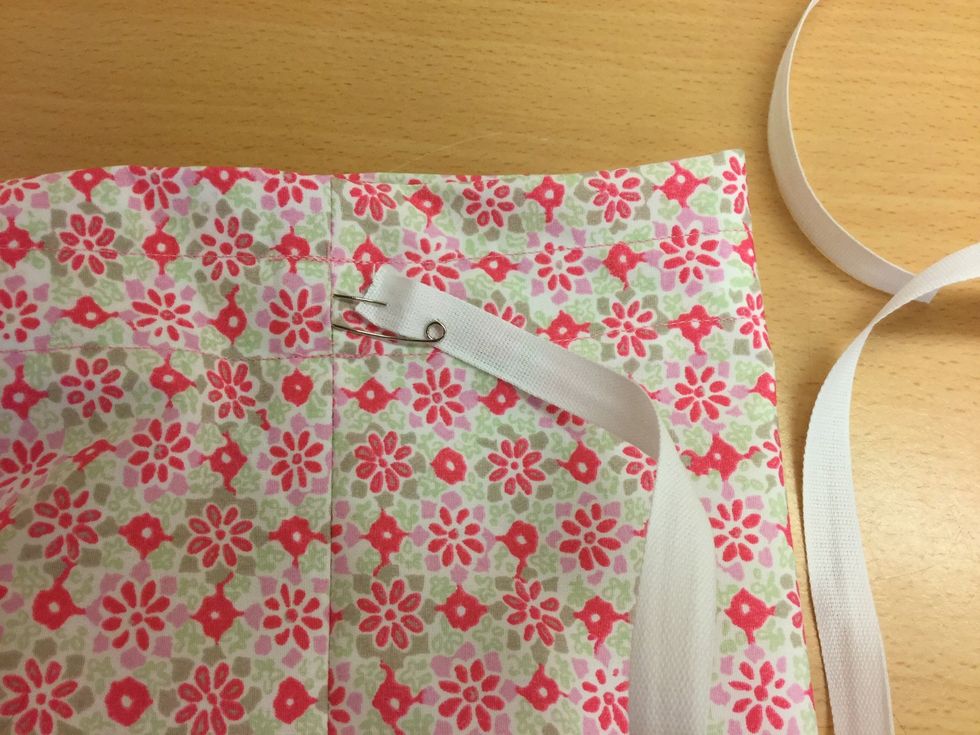 Tr\u00e4 i banden. B\u00f6rja med det ena bandet. Tr\u00e4 det runt hela p\u00e5sen och knyt ihop. G\u00f6r likadant med det andra bandet, men b\u00f6rja nu fr\u00e5n sidan.