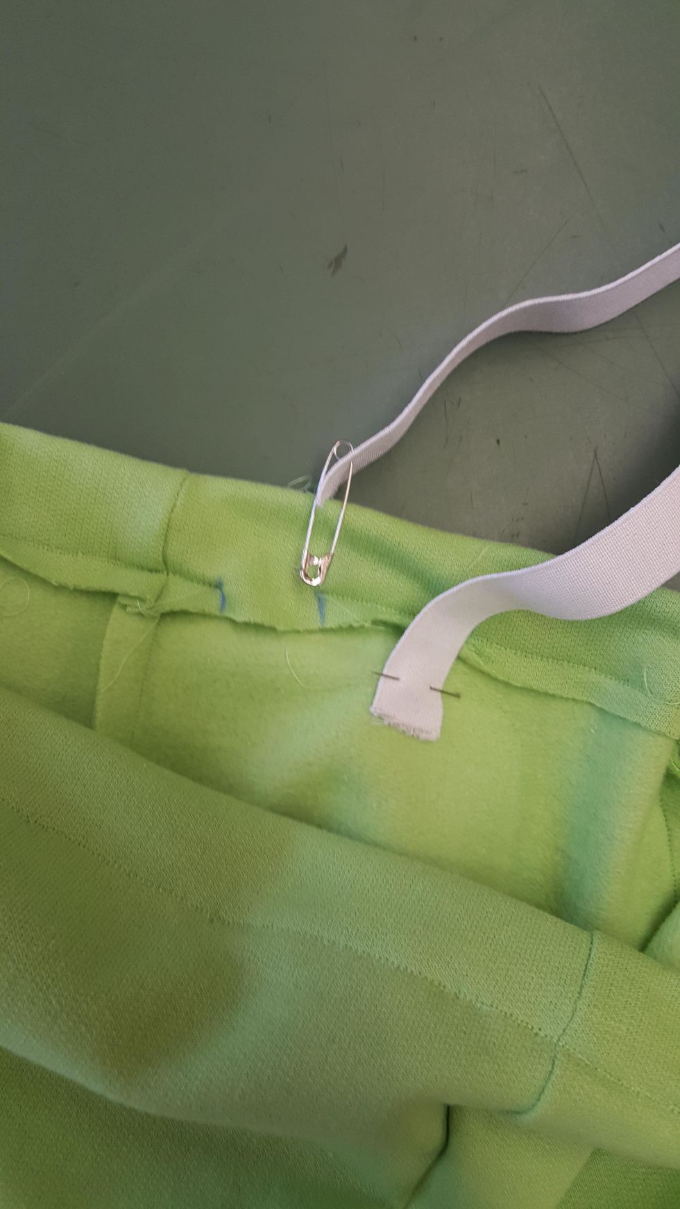 Tr\u00e4 in en res\u00e5r i kanalen med hj\u00e4lp av en s\u00e4kerhetsn\u00e5l. N\u00e5la fast den andra \u00e4nden i byxan med en knappn\u00e5l