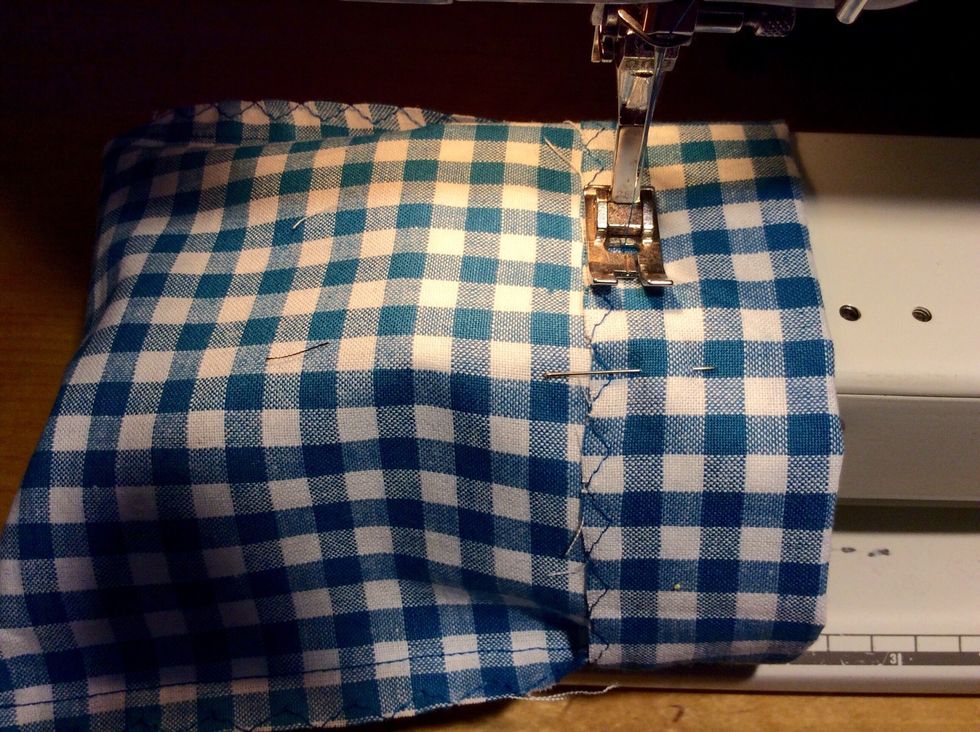 Tr\u00e4 p\u00e5 p\u00e5sen p\u00e5 symaskinens arm. Sy raks\u00f6m en pressarfots bredd fr\u00e5n kanten.