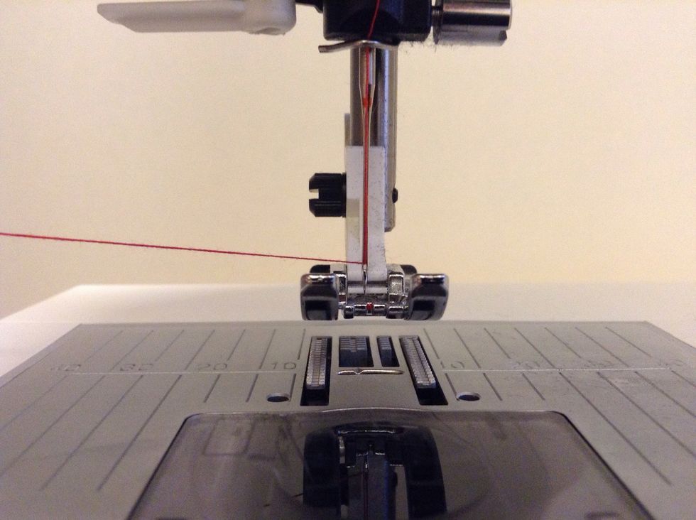 Tr\u00e4 tr\u00e5den genom n\u00e5ls\u00f6gat. Det kan g\u00e5 l\u00e4ttare om du f\u00f6rst klipper av tr\u00e5den.