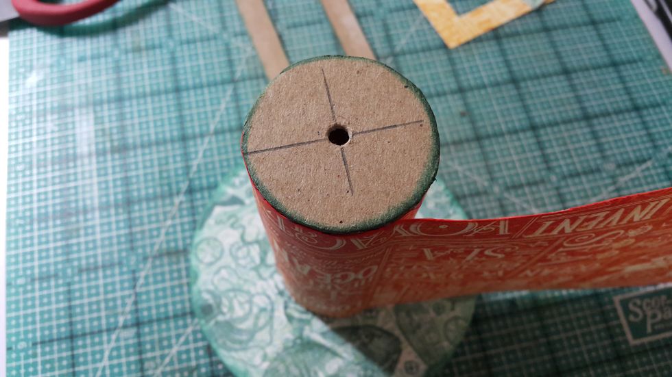 Trace and cut chipboard for the base of the tissue roll, punch a hole in middle. Then adhere one end of the tissue roll with the large circle in step 5 and the other end with the small one just cut.