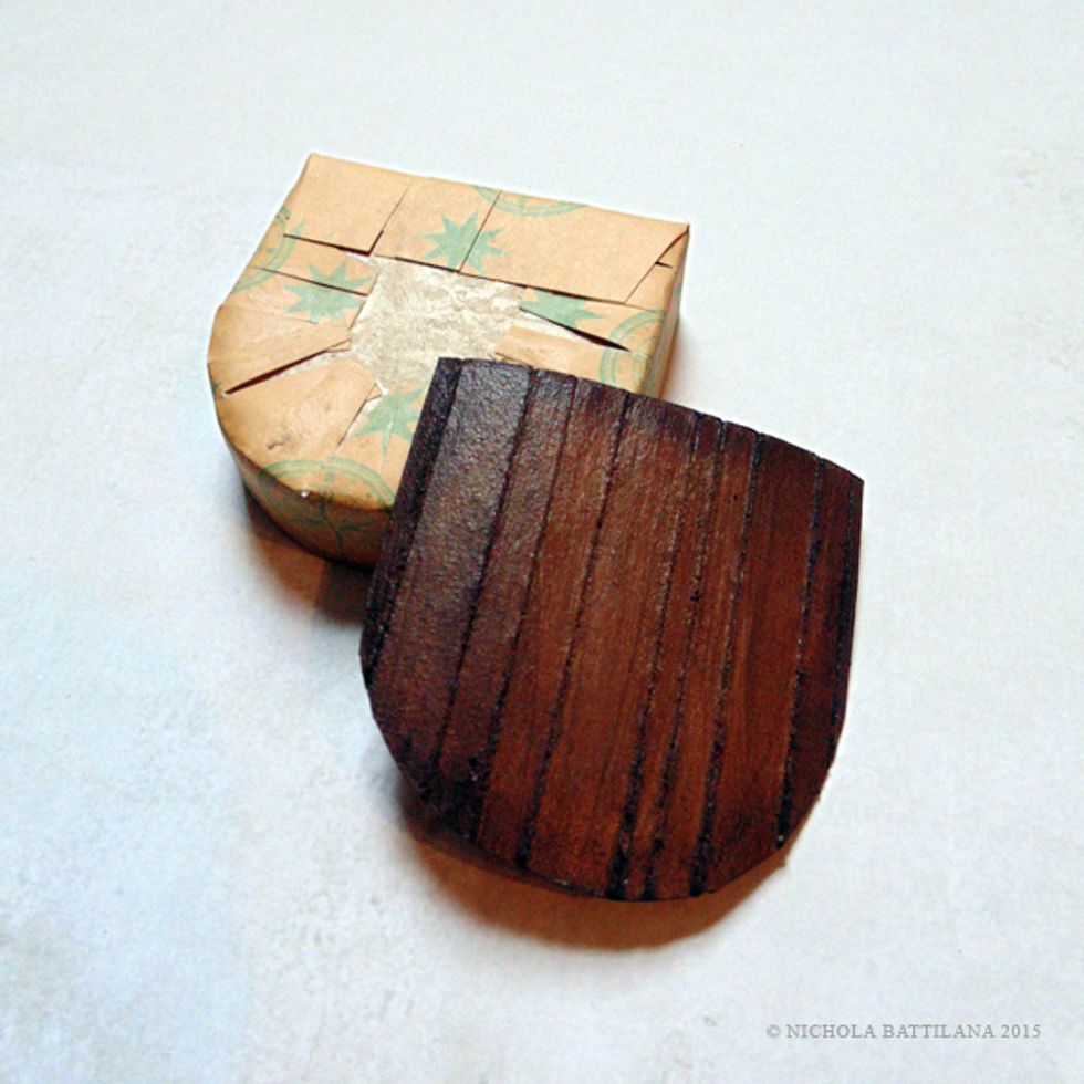 Trace and cut the shape of the stage onto thick card. Using a stylus type tool, score lines into the card to simulate wood planks. Paint with brown acrylic and apply darker washes to add depth.