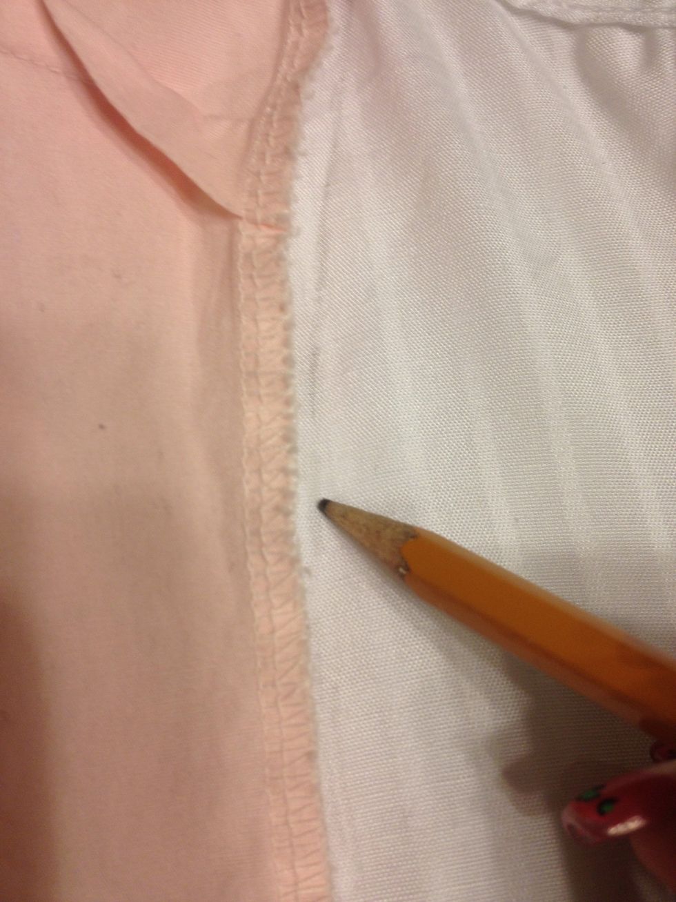Trace the edge of the pink shirt. Along the seam from under the armpit down.
