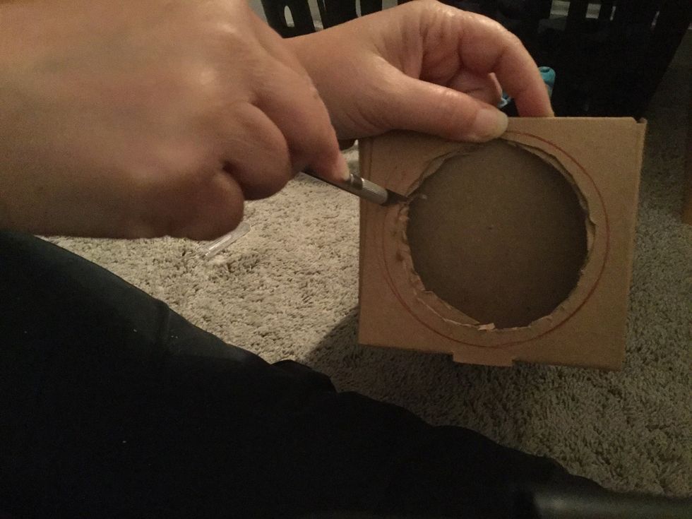 trace the glass on the box and cut it, you may want to cut the hole of it a little smaller than the trace so it won't fall through, it would be easier to use an exacto  knife rather than scissors