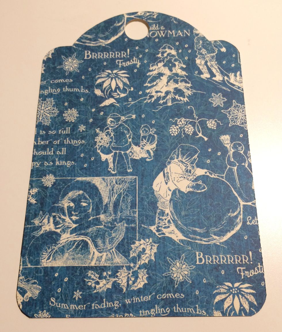 Trace the tag around January Calendar page. Once the tag is traced, cut the tag out. To finish the tag, use a 1/2" circle punch and punch a hole at the top of the tag. Round all four corners.