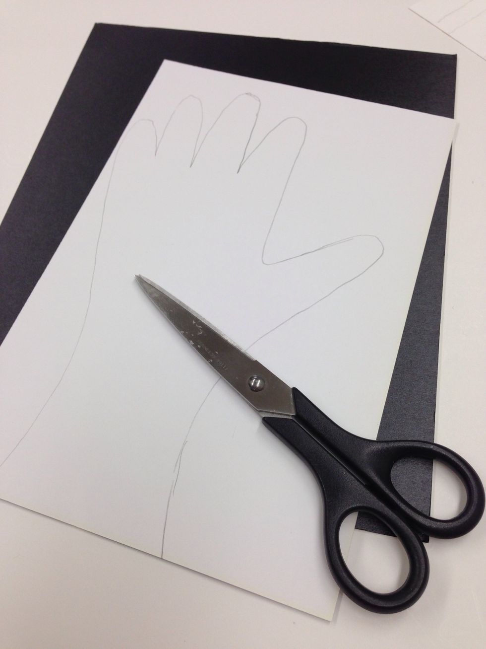 Trace your left hand onto the BACK of the scrapbook paper piece and cut it out with your scissors.