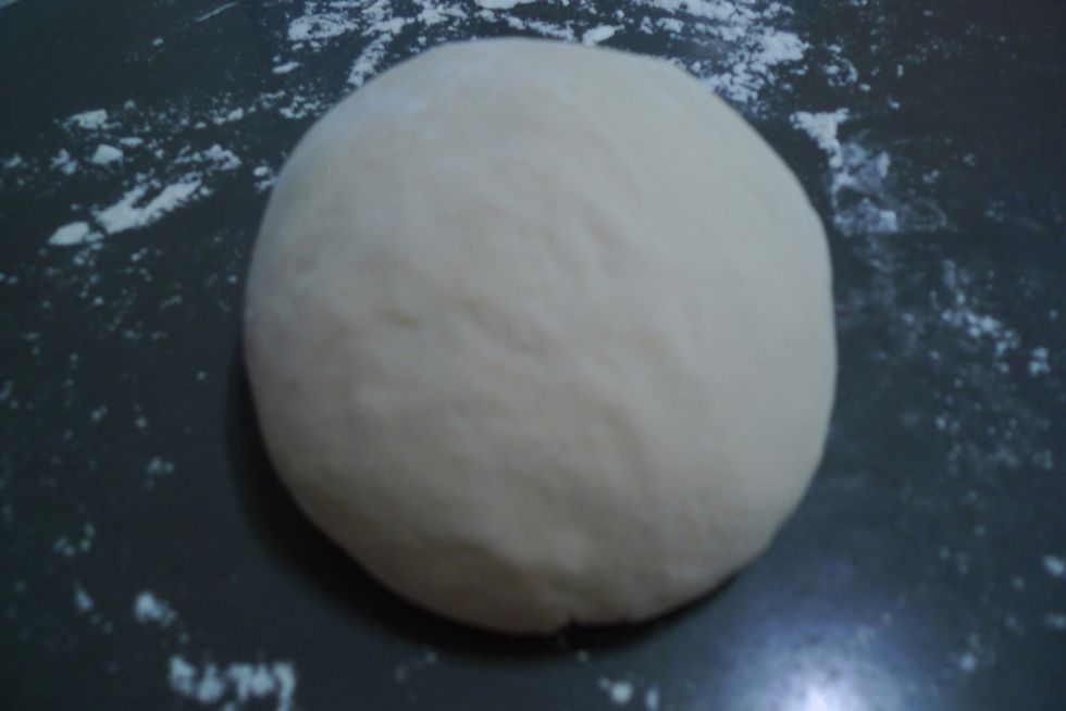 Transfer dough to a floured work surface. Dough will be elastic and sticky but not stick to your fingers. Shape the dough lightly into a smooth round shape, gently tucking loose end underneath dough.