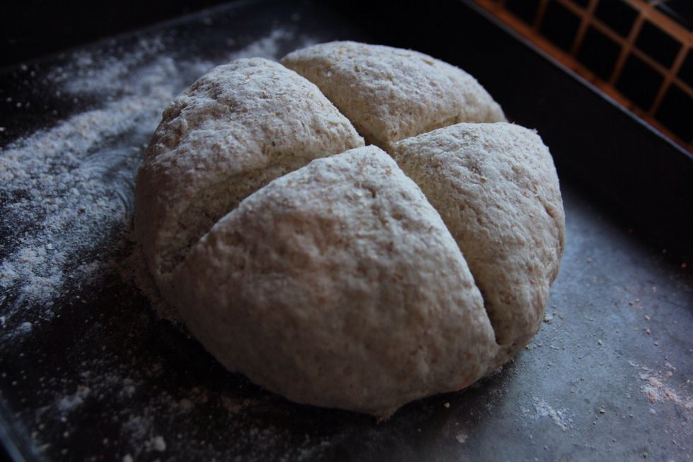Transfer loaf onto a floured baking tray. Score a cross in the loaf to a depth of about 2\3rds of the loaf. Push the loaf together after this as it may spread out. Put into oven and cook for 35mins.
