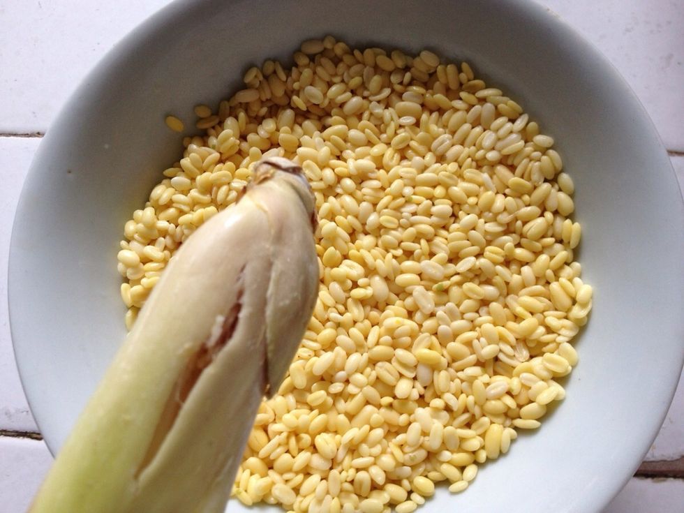 Transfer the mung dal to a shallow bowl and add in 1 stalk lemongrass (bruised the edge)
