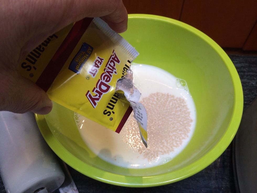 Transfer the warm milk to a bowl. Add 2 packages of active dry yeast (1/4 ounce each) and a pinch of sugar. Let stand for 5-10 minutes until foamy.