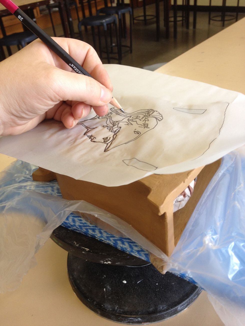 Transfer your tracing paper designs and motifs to your pot by tracing with a pencil.