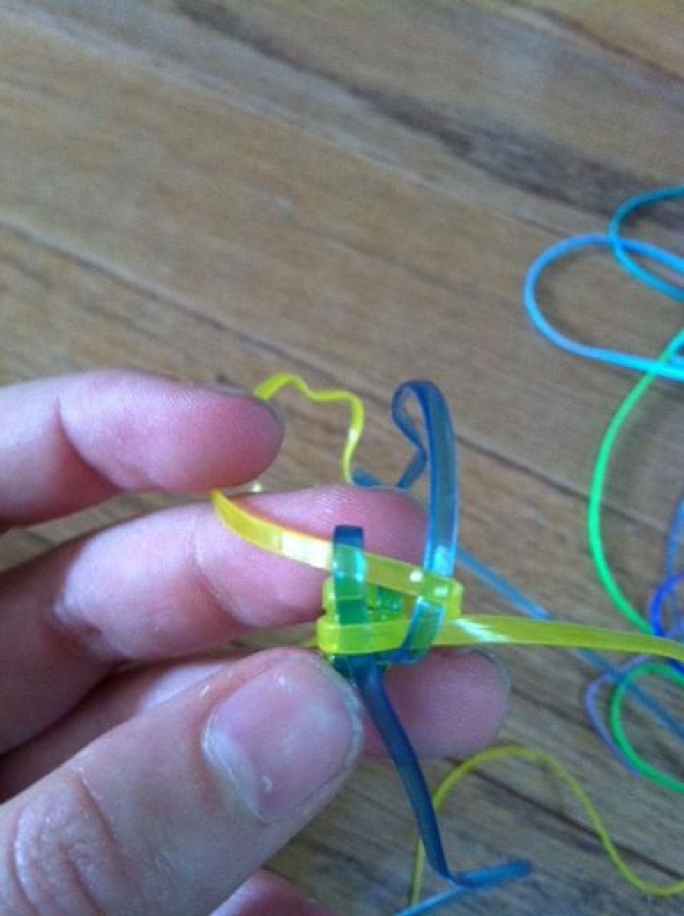 Tread the other yellow lanyard over the first blue loop and under the second one.
