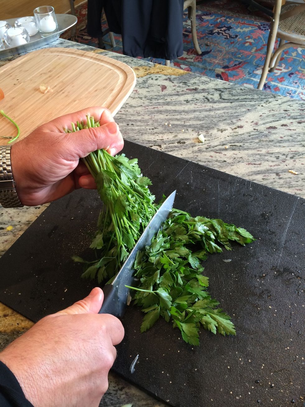 Trim by using the knife lightly to cut the leaves from the stems while you turn the entire bunch around exposing more uncut leaves.