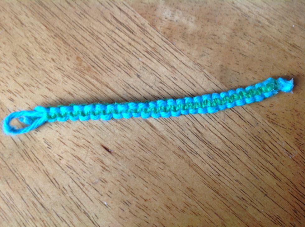 Trim off that extra base yarn and this should be the final product. To attach to your wrist, pull the bottom notch/knot through the loop at the top.