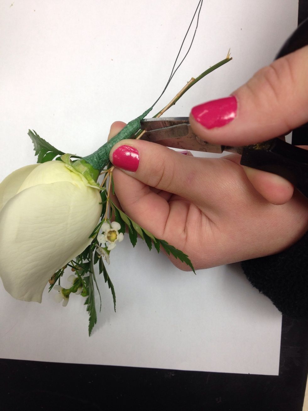 Trim ONLY the stems of the greens and filler flower to the same length as edge of rose's stem.