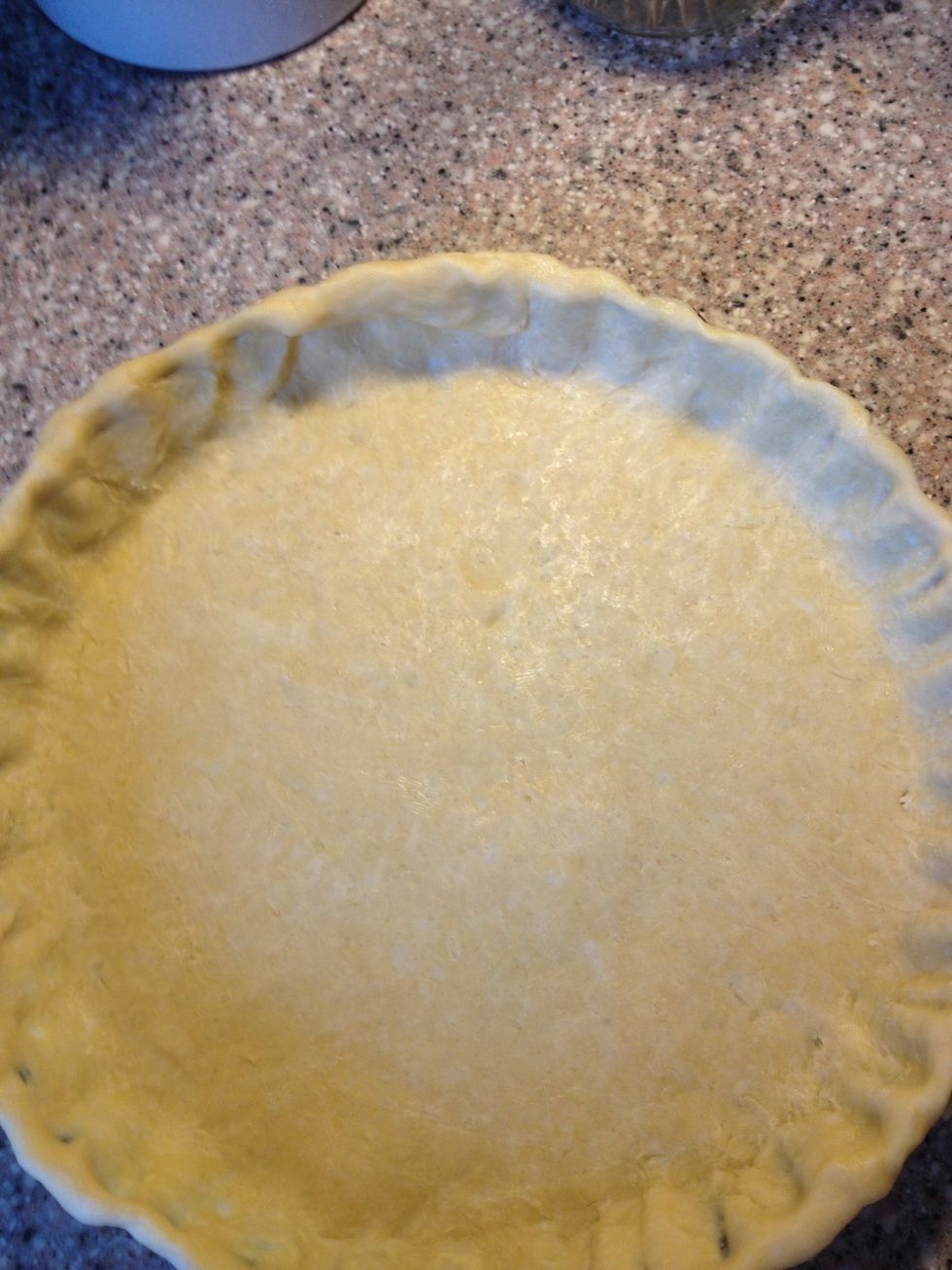 Trim overhanging dough, by tucking it under itself. Crimp dough evenly around edge of pie using your fingers. Wrap again loosely in plastic and refrigerate again for 15 minutes before baking it.