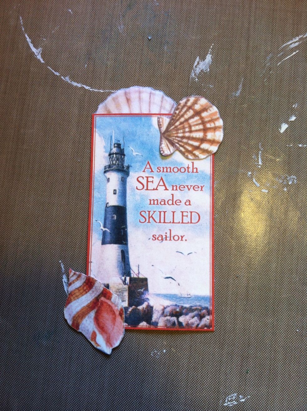Trim the blue border from the lighthouse card. I glued a few shells on the front. I wanted to cover the lighthouse name as I felt it took away from the phrase on the card.