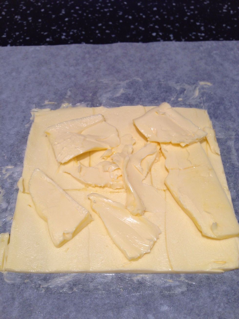 Trim the edges of the butter and out the trimmings on top of the square. Pound again lightly until you have a final square of 17x17cm
