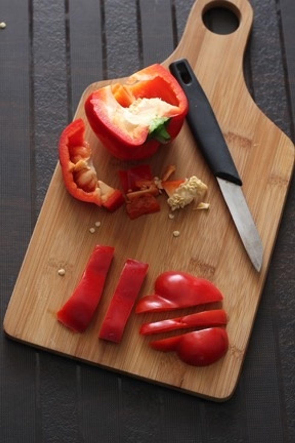 Trim the end of the bell pepper  and cut it  into 3 parts .Cut out 2 large rectangular pieces from a side.