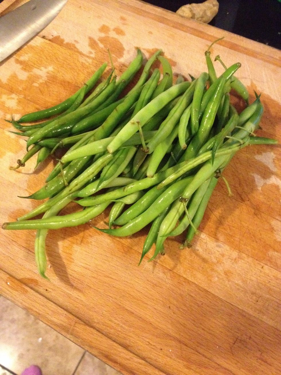 Trim the green beans by \u201csnapping\u201d off the ends\u2013fresh beans will snap easily, and if there is a fiborous, stringy seam along the bean, this can be pulled off as well.