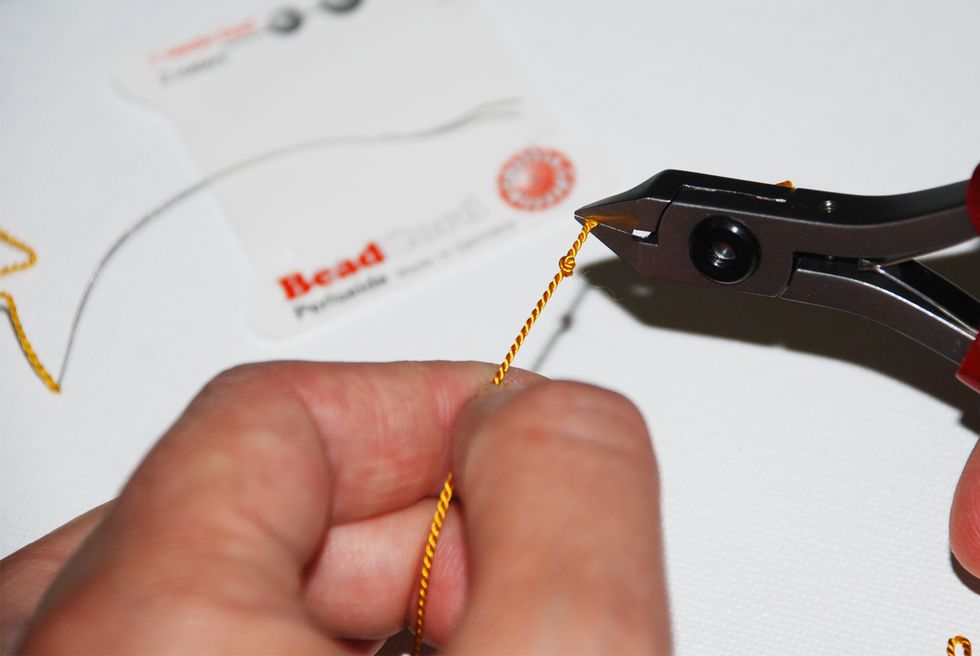 Trim your thread about 1/2" from the knot with your wire/string cutters. Make sure your tool is sharp to reduce fraying.