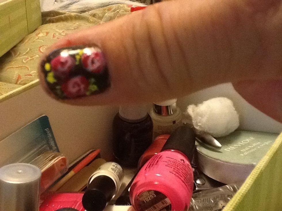 Try adding some little yellow squiggles around the flowers. This is a nail art polish that has a skinny brush. Nothing special, just some jiggly squiggles.