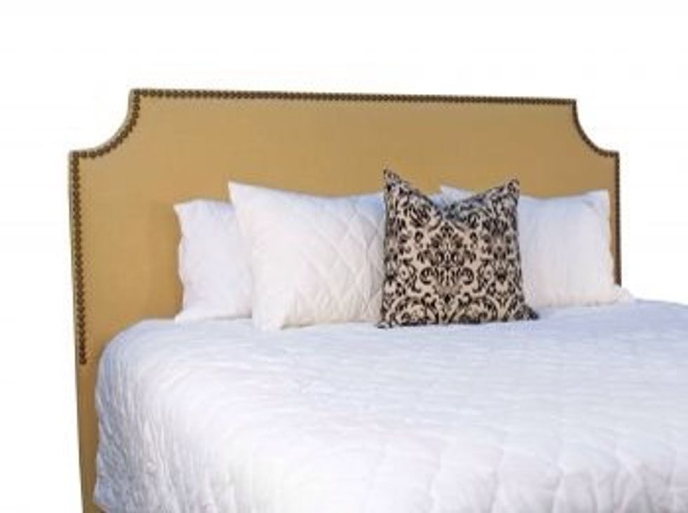 Try an upholstered headboard placed flush against the wall instead of a traditional oversized wooden frame.