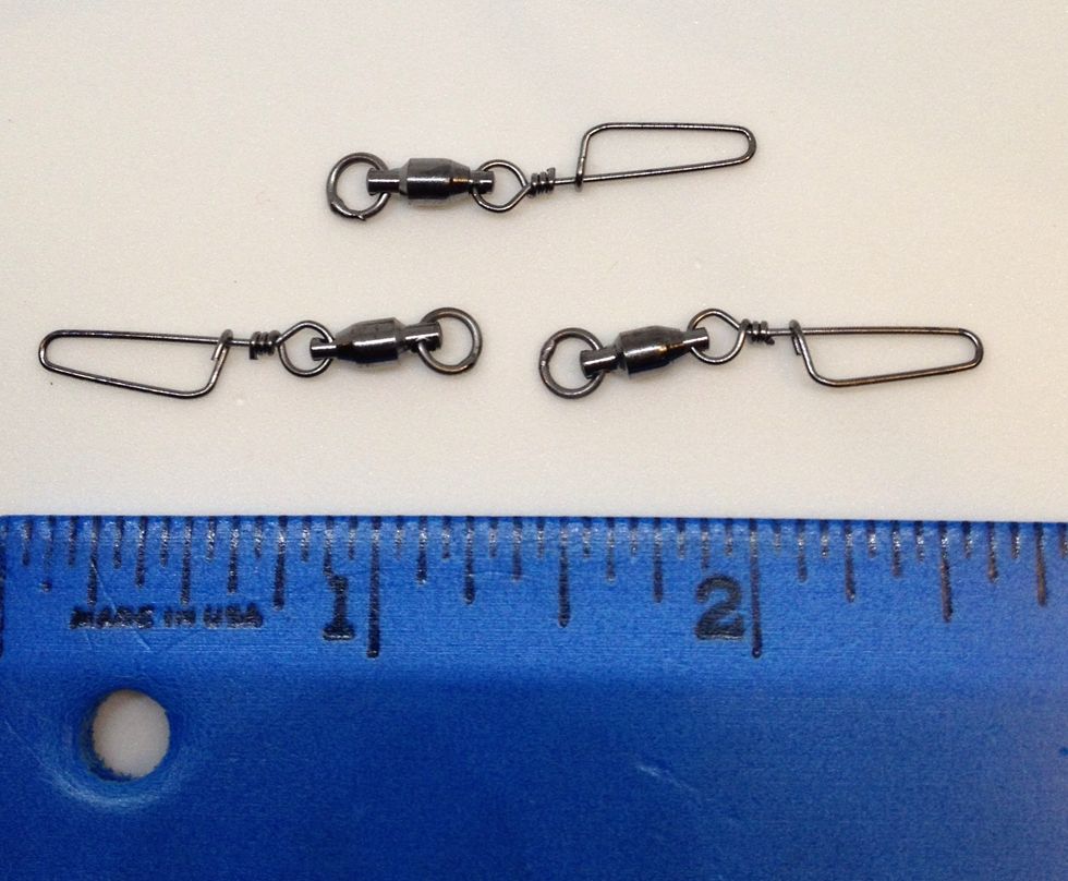 Try and find a ball bearing fishing swivel size 1 with a coastlock snap. The snap is placed inside the ball. These are cheap and available in fishing shops or on eBay. Normal swivels should work too.