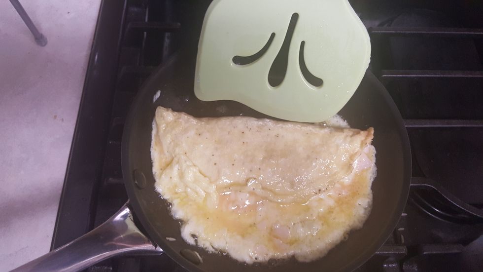 Try and shape your omelette into a circle. When your omelette begins getting hard from the heat, gently flip it over with your spatula so that the heat evenly distributes.