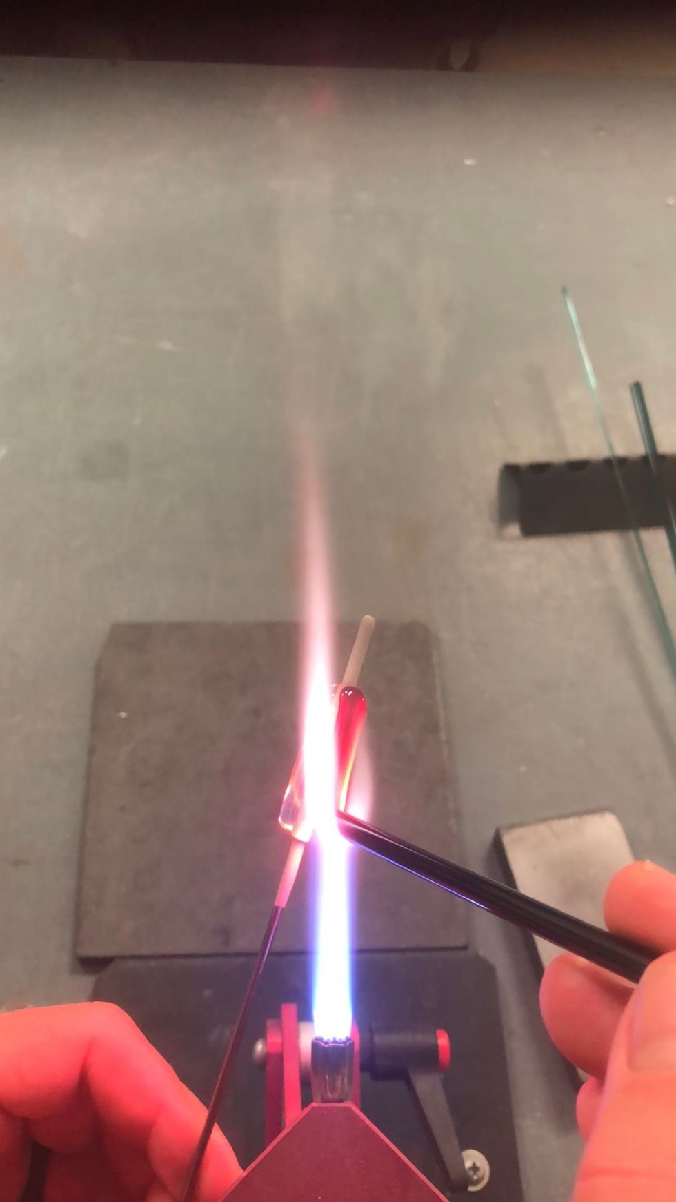 Try to push the bead while feeding the rod into the flame. Feeding through the same location in the flame makes for consistent heat and a consistent stripe.