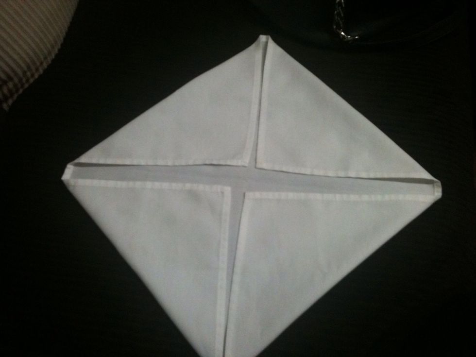 Try your best to fold all fours sides evenly to get a triangle like so.