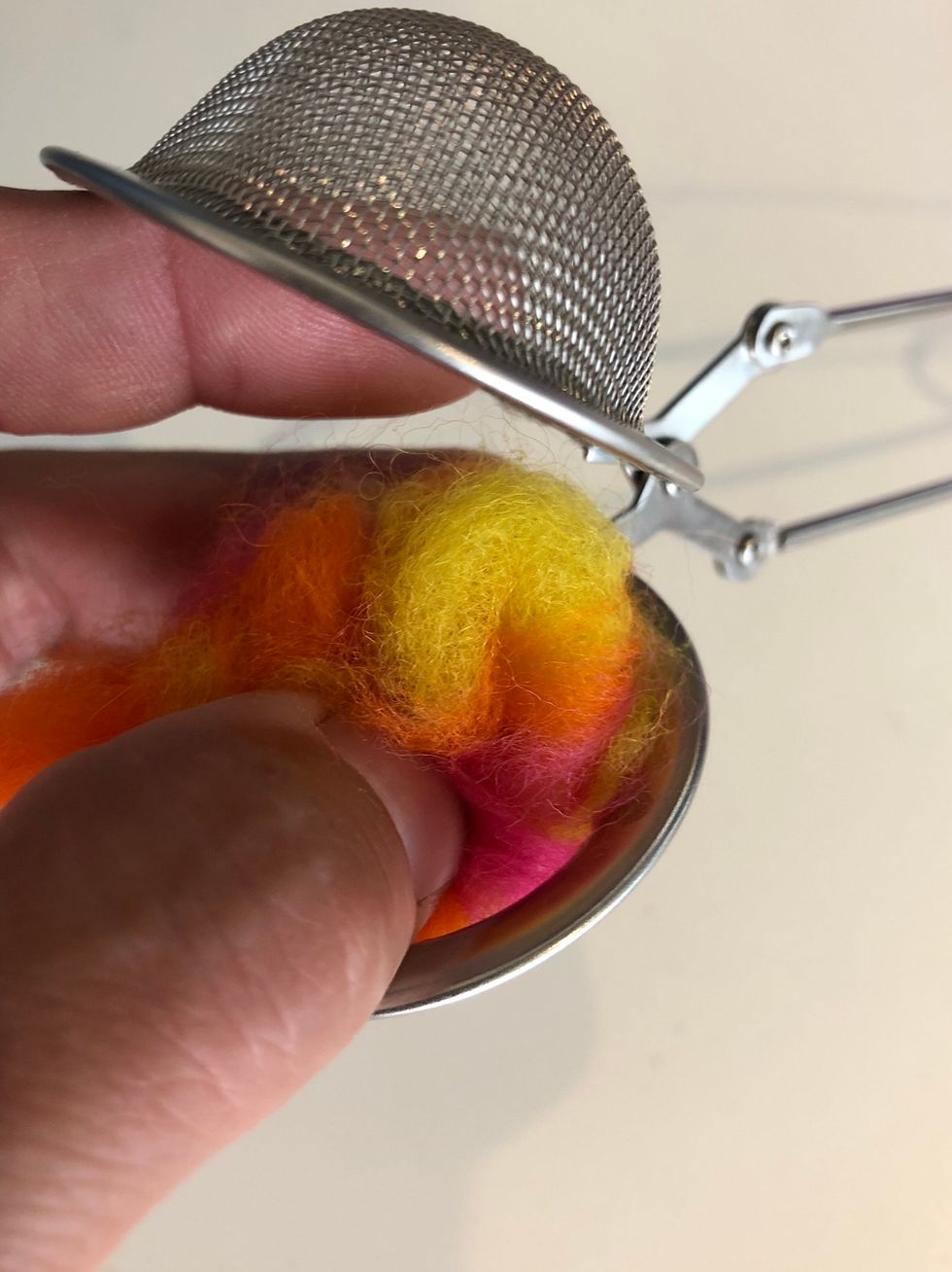 Tryck in ullen i te kulan. Den ska vara full med ull.