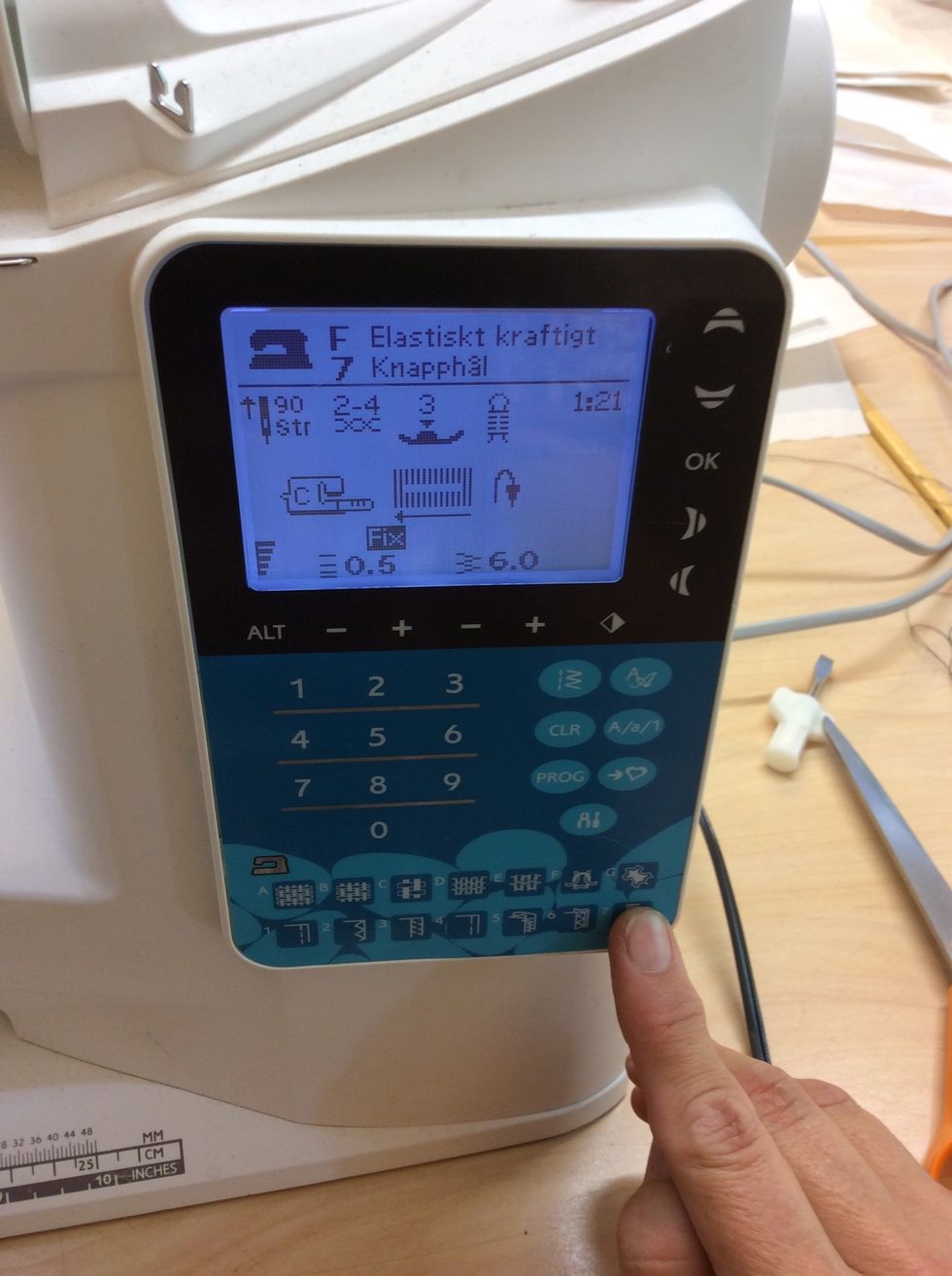 Tryck p\u00e5 knapp nr 7 allra l\u00e4ngst ner i h\u00f6gra h\u00f6rnet p\u00e5 symaskinen f\u00f6r att st\u00e4lla in r\u00e4tt knapph\u00e5l.